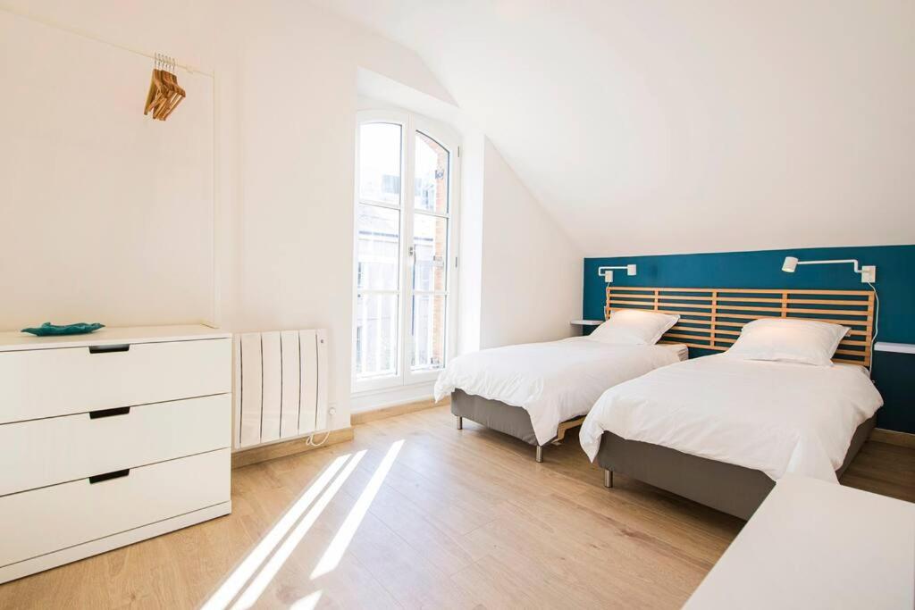 奥尔良La Madeleine Maison *T3*的一间卧室配有两张床和梳妆台。