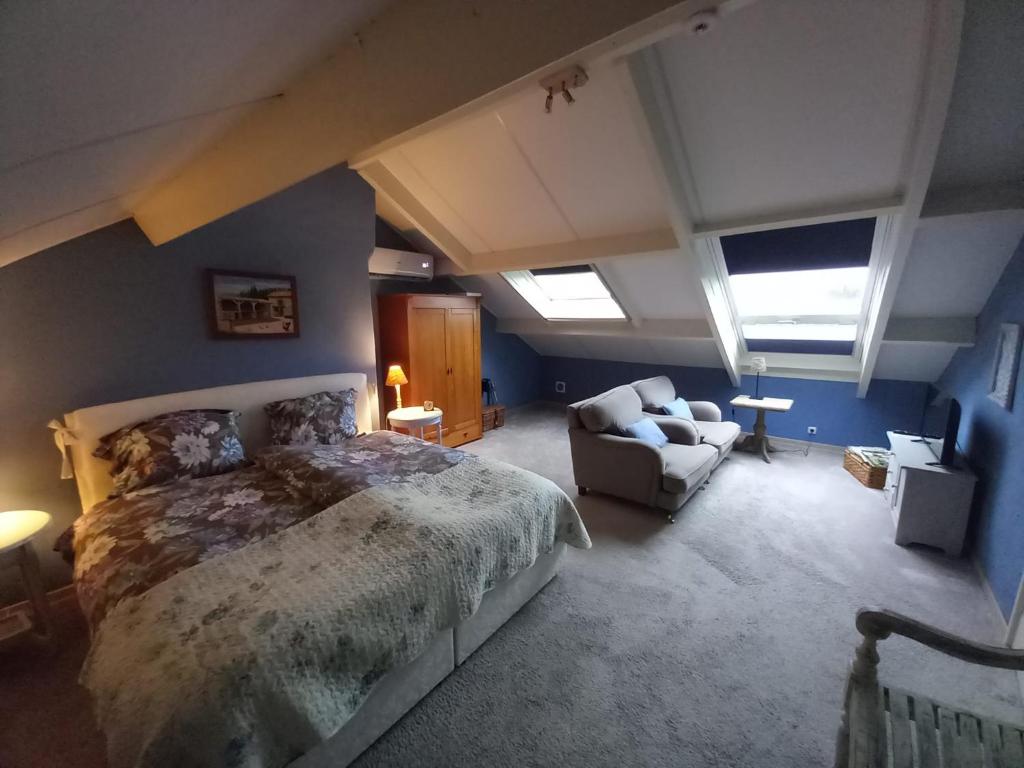 MoorveldDe Hagendoorn的一间卧室配有一张大床和一张沙发