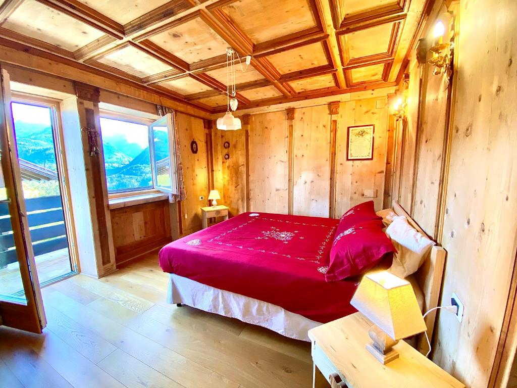 卡拉诺Casa Francesca的一间设有红色床的卧室,位于一个木墙的房间