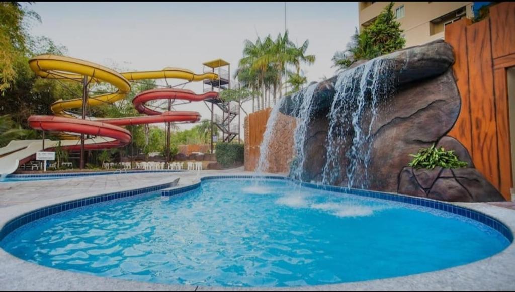 卡达斯诺瓦斯Golden Dolphin Grand Hotel的一个带水滑梯和瀑布的游泳池