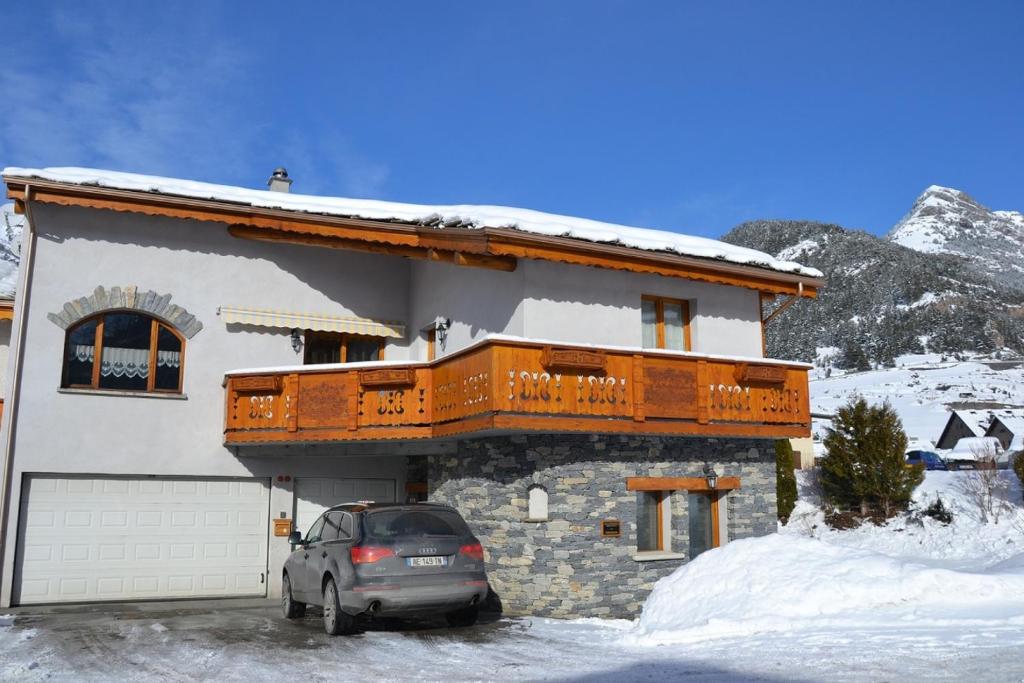 泰尔米尼翁"L'Ancolie" Appartement de Charme 4 Personnes à Val Cenis的雪中停在房子前面的汽车