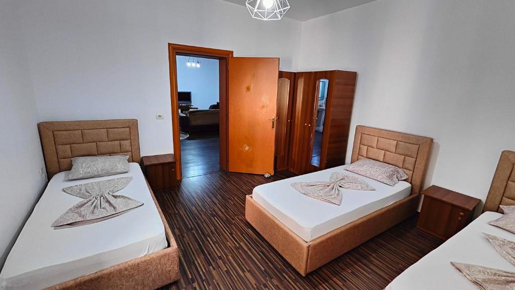 斯库台Appartamento familiare di Toni的一间带两张床的卧室和一个带门的走廊