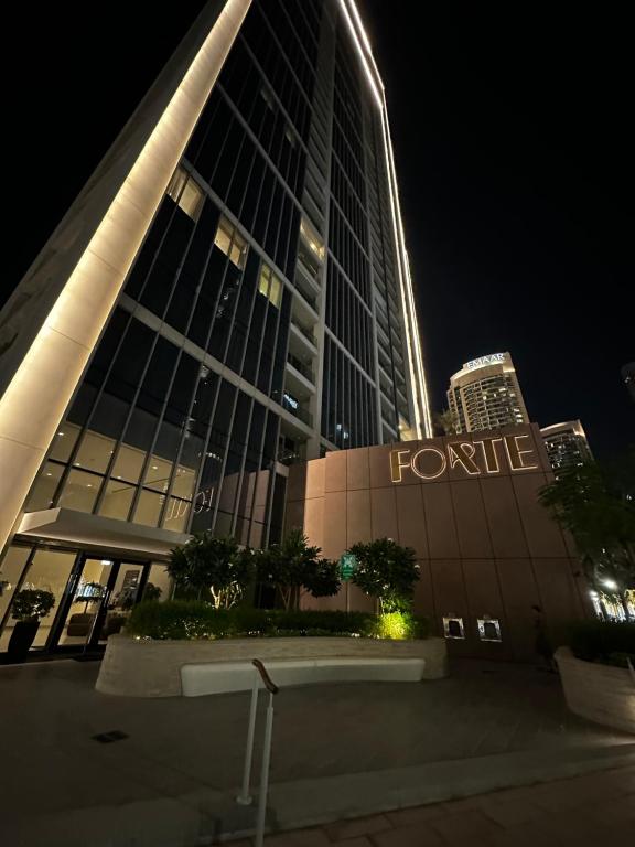 迪拜Forte Downtown Dubai的一座在晚上有标志的三线建筑