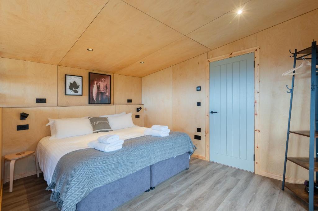 圣安德鲁斯Rustic Cabins, sea views from rewilded farm的一间卧室配有带毛巾的床