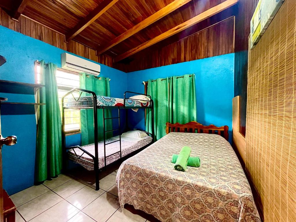曼努埃尔安东尼奥Pura Natura Lodge Manuel Antonio的一间卧室设有两张双层床和绿色窗帘