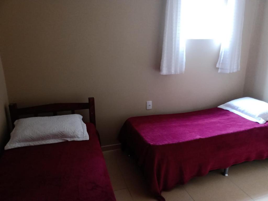 加拉尼温斯Apê perto do Parque Euclides Dourado的一间卧室设有两张床和窗户。