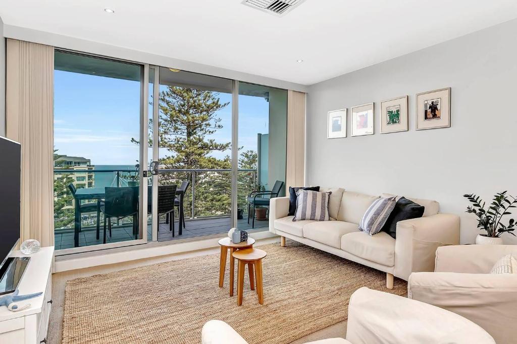 格莱内尔格Waterfront Resort-Style Living at Glenelg Beach的带沙发的客厅,享有海景