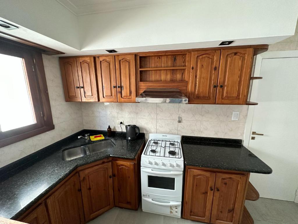 内科切阿Mar y Cielo的厨房配有木制橱柜和白色炉灶烤箱。