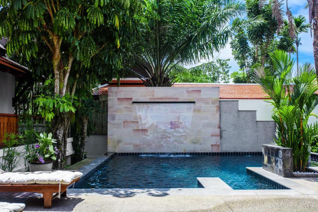 普吉镇Luxurious Residence Rawai的树木繁茂的庭院中的一个游泳池