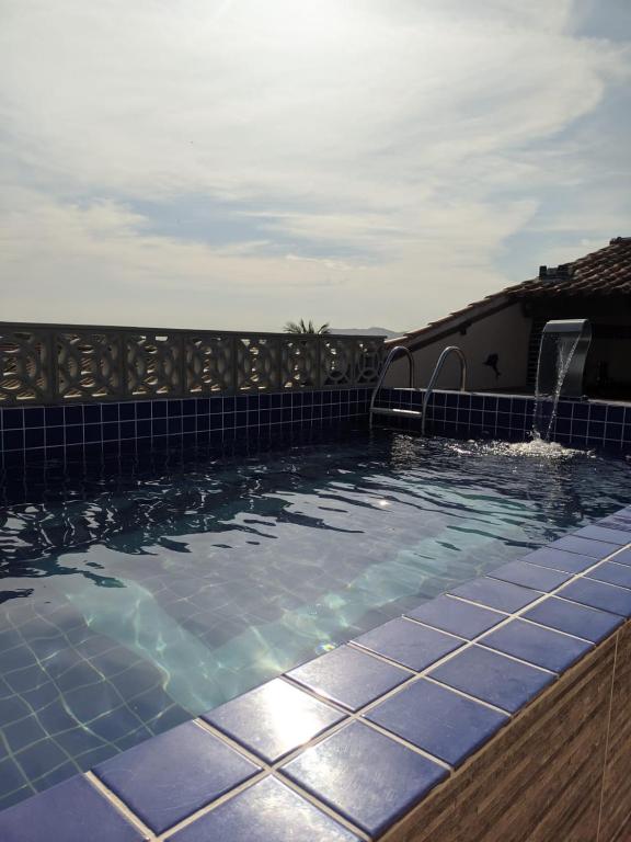圣佩德罗-达阿尔德亚Região dos Lagos - casa para temporada的一座位于房子一侧的蓝色瓷砖游泳池