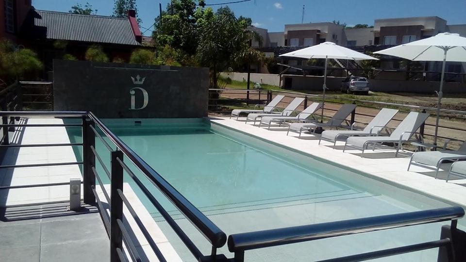 查哈里DINASTIE APART HOTEL的一个带躺椅和遮阳伞的游泳池
