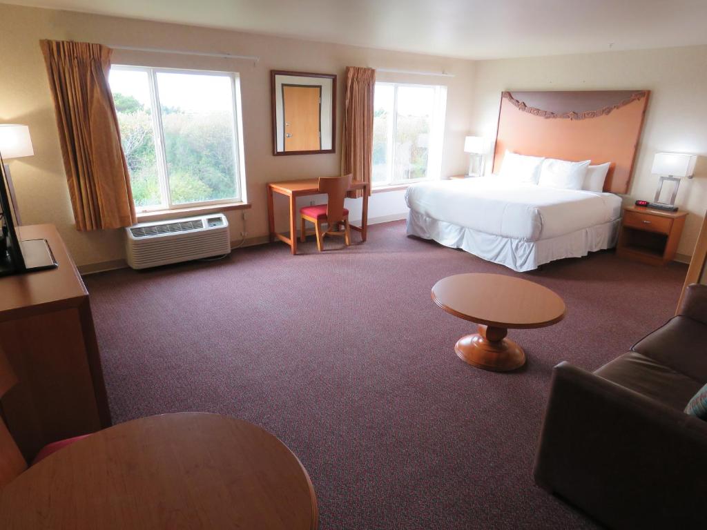 洋滨市Pacific Sunrise Inn & Suites的酒店客房,配有床和沙发