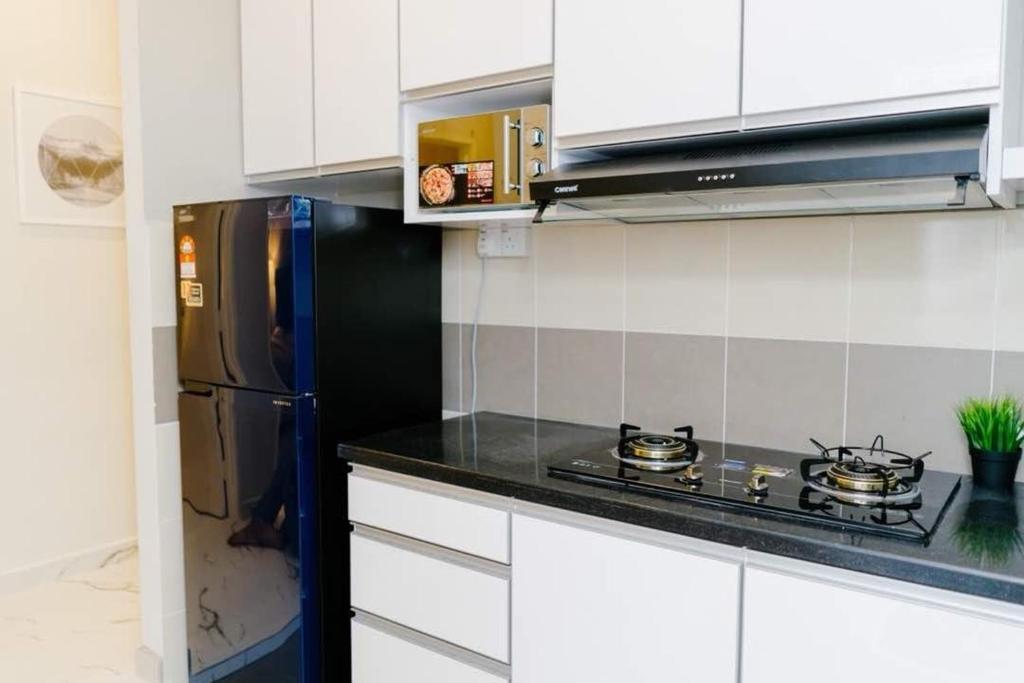 瓜拉丁加奴Mimpi D View Homestay的厨房配有黑炉和冰箱。