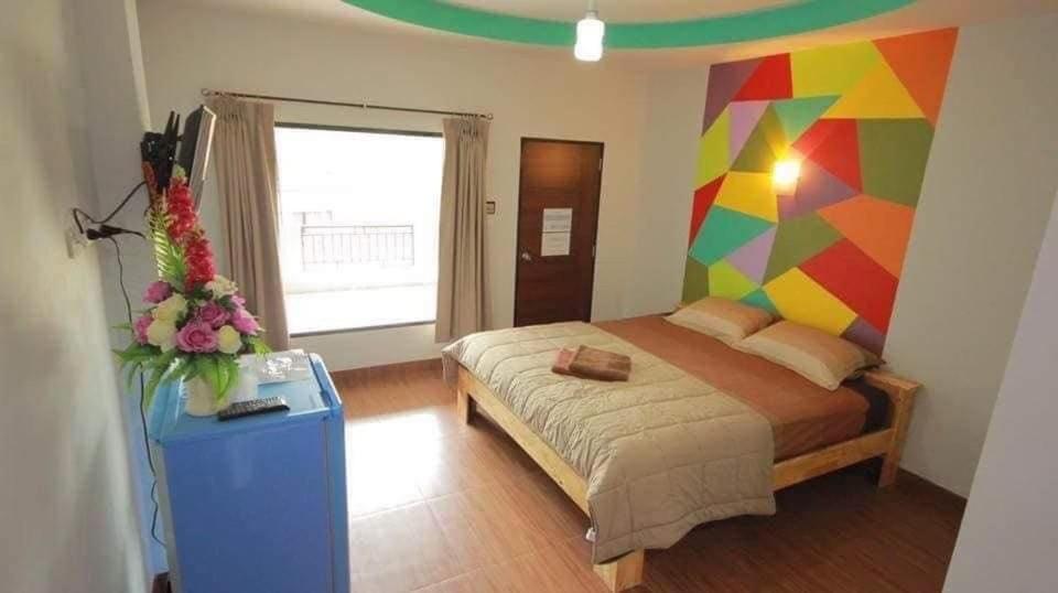 Ban Khao NoiThe shark resort ปราณบุรี的一间卧室配有一张带彩色墙壁的床
