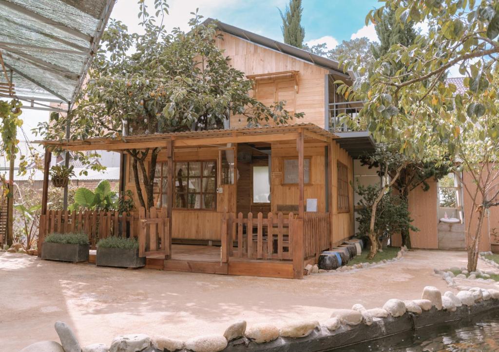 大叻Mơ Garden Retreat DaLat的一座带门廊的小木房子