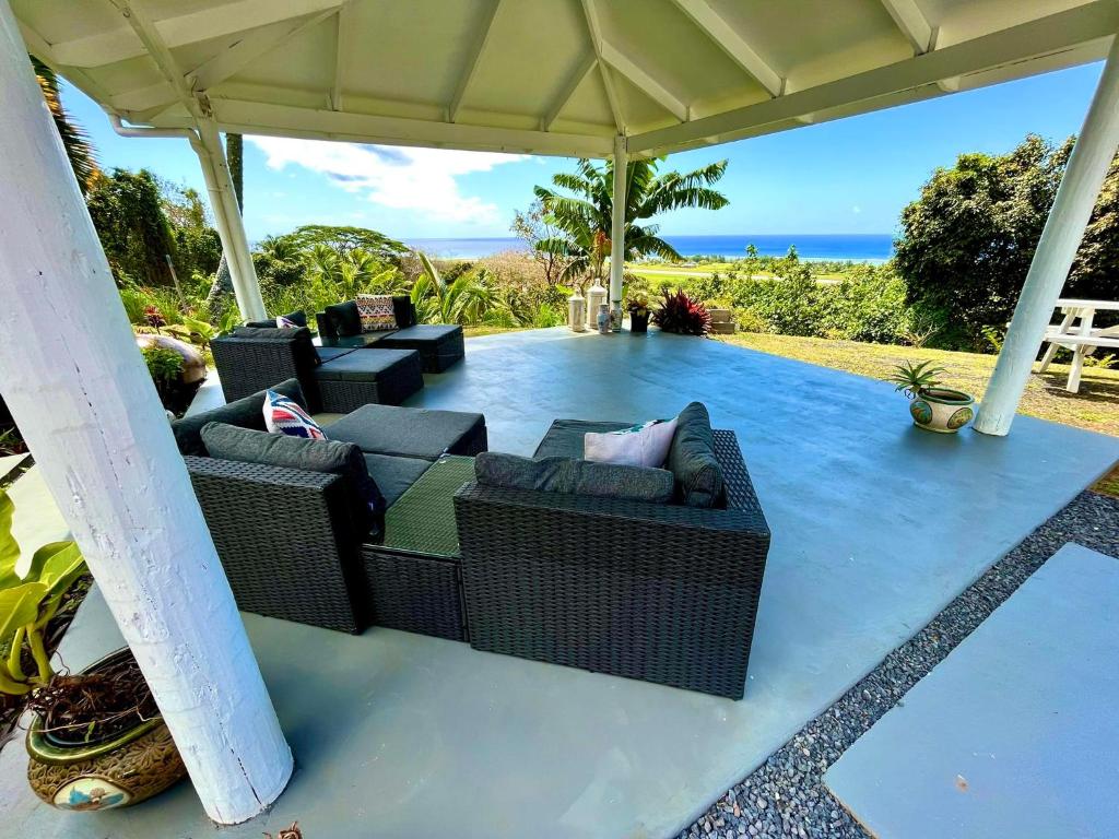 阿瓦鲁阿Tereora Heights Pool Retreat的一个带柳条家具的户外庭院和大海