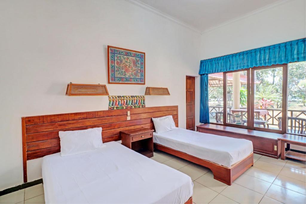 BanyubiruCapital O 93236 Hotel Hapel Negara的酒店客房设有两张床和一个阳台。