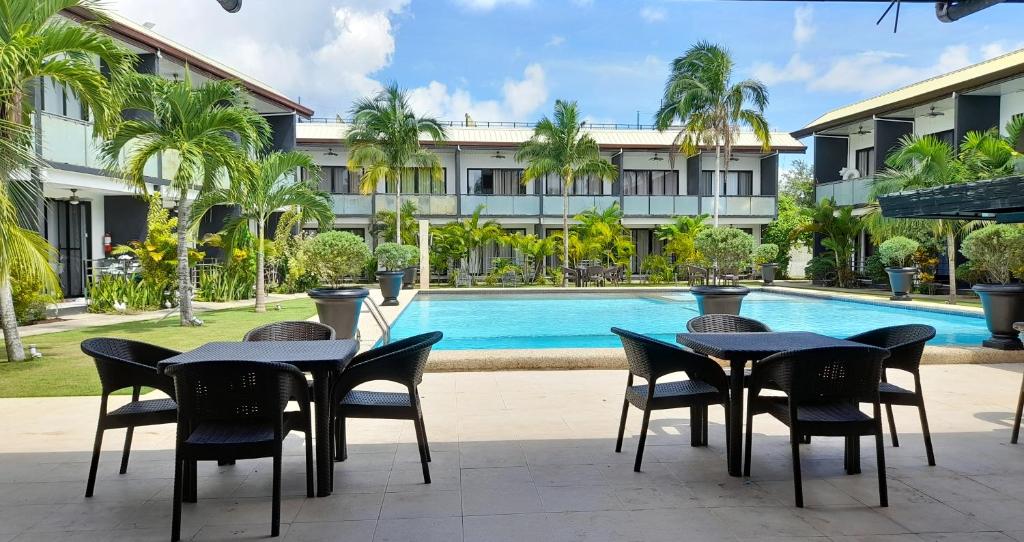 道伊斯Bohol Jewel Resort的游泳池旁的酒店设有桌椅
