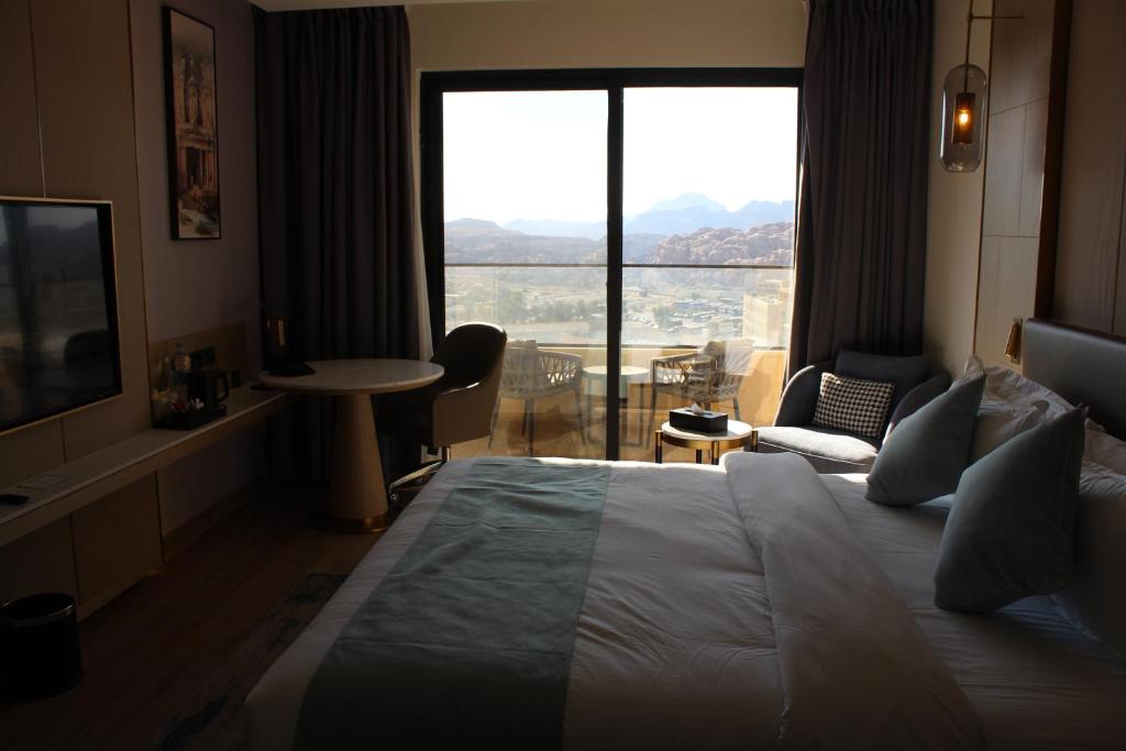 瓦迪穆萨H Luxury Hotel的一间酒店客房,设有一张大床和一个大窗户