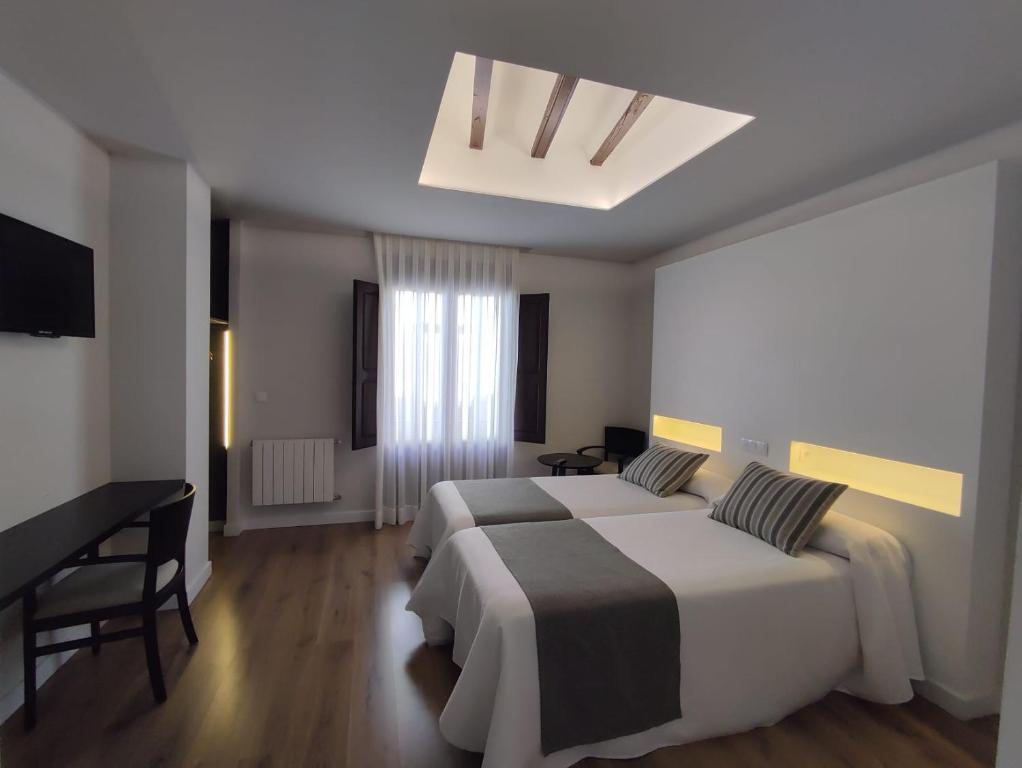 卡拉瓦卡·德·拉·克鲁斯Hotel La Vera Cruz的酒店客房配有两张床和一张书桌