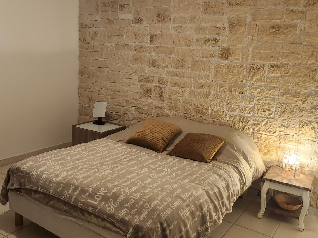尼姆Maison tout confort的一间卧室设有一张床和砖墙