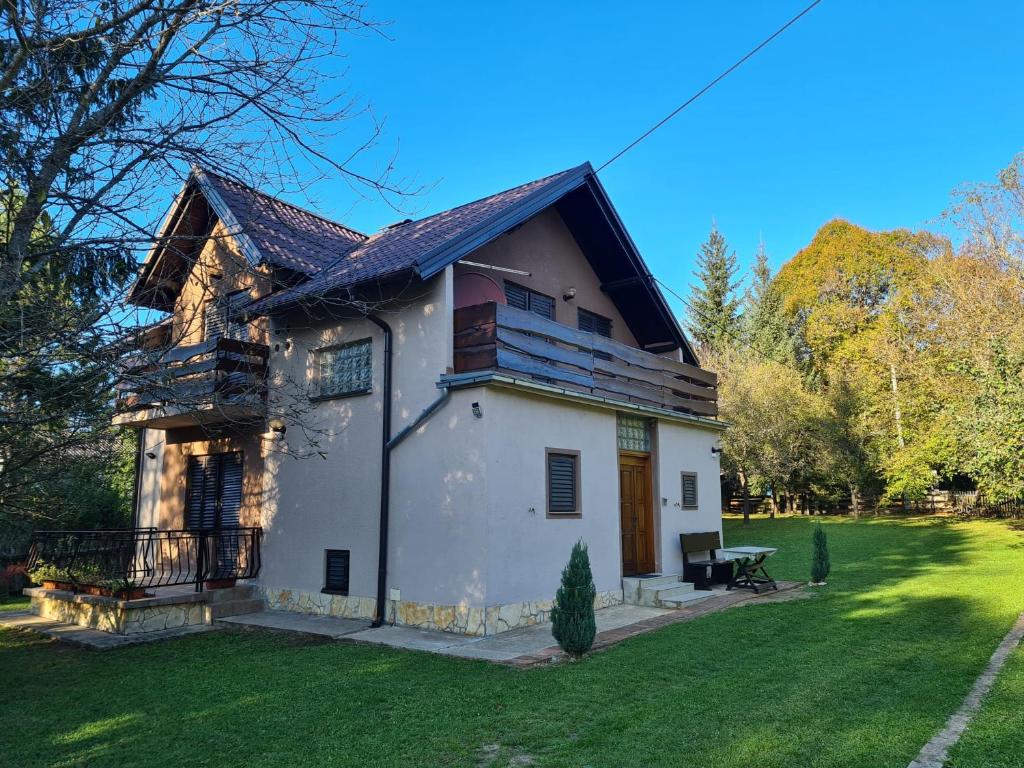 RudanovacHoliday Home "Iris" near Plitvice Lakes的一座带草地庭院的大型白色房屋