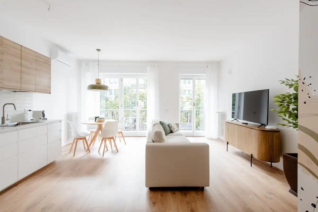 米兰Luxury 2 bedroom Apartament, close to San Siro, Fiera and 10 min metro to Duomo的白色的客厅配有白色的沙发,厨房