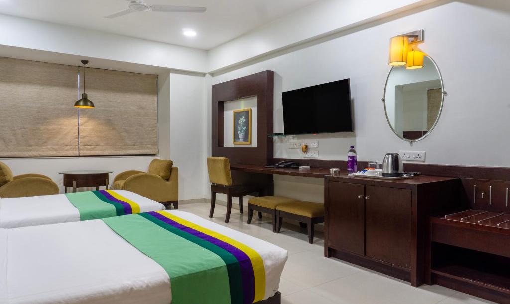 浦那Treebo Trend Bhairavee - Baner的配有一张床和一张书桌的酒店客房