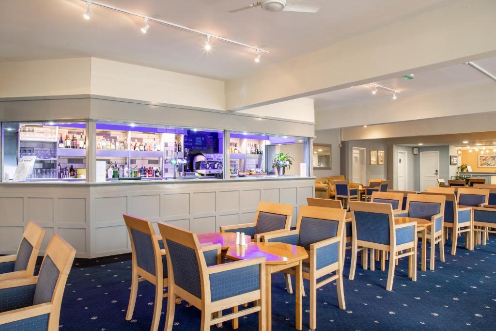 蒂弗顿Tiverton Hotel Lounge & Venue formally Best Western的一间带桌椅的餐厅和一间酒吧