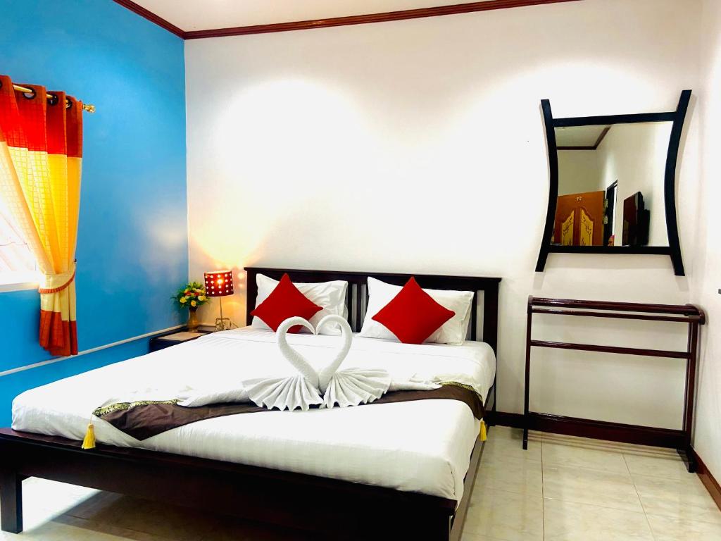 高兰Lanta Grand House的一间卧室配有红色和白色枕头的床