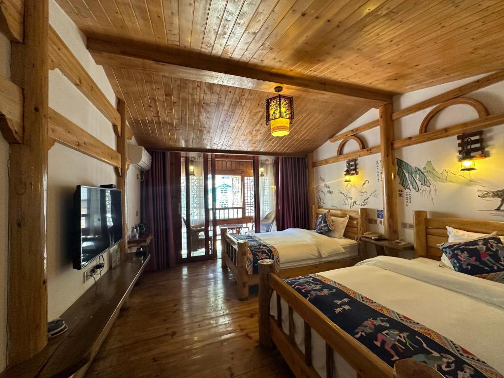 张家界Mountain View Guesthouse的一间酒店客房,设有两张床和电视