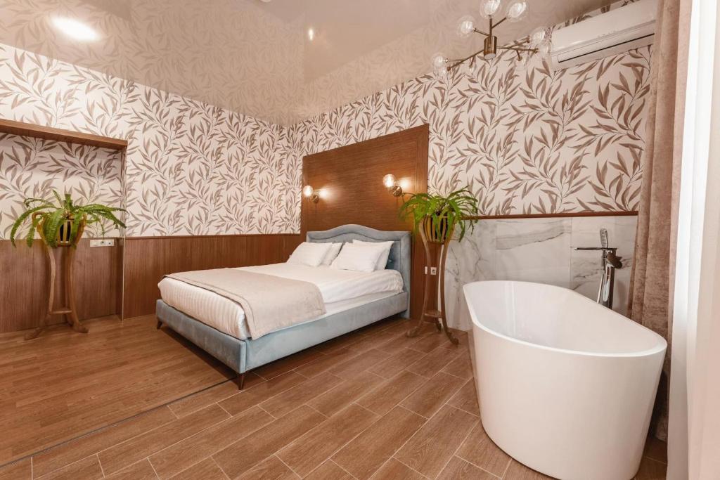 茨卡尔图博Park Hotel Tskaltubo - Balneo Resort的一间卧室配有一张床和浴缸