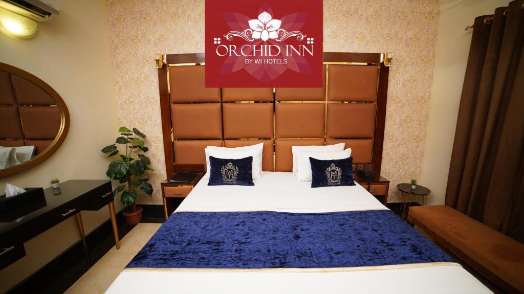 卡拉奇Orchid Inn by WI Hotels的酒店客房,配有一张带蓝色毯子的床