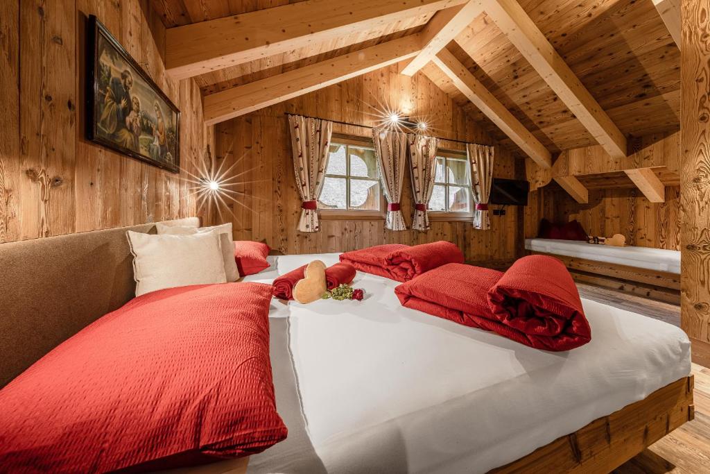 巴迪亚FARM CHALET JUSCIARA的一间卧室配有一张带红色枕头的大床