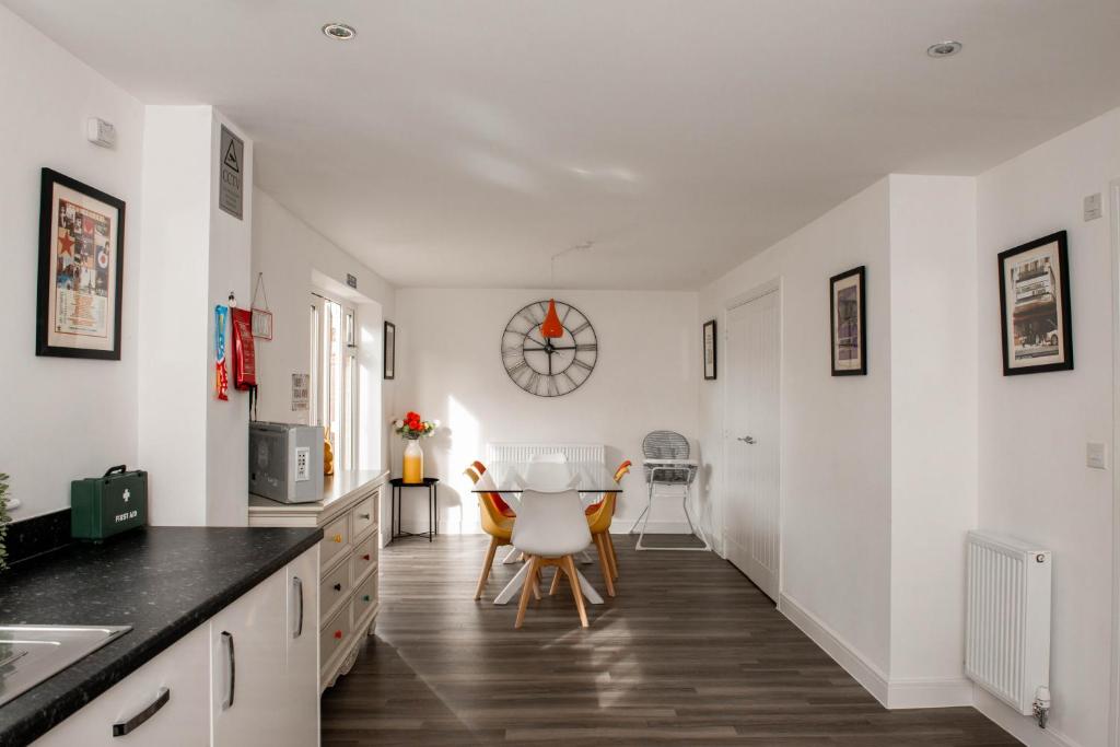 南安普敦Spacious & Stylish 4-Bed House with Hot Tub in Prime Location的厨房拥有白色的墙壁和桌椅