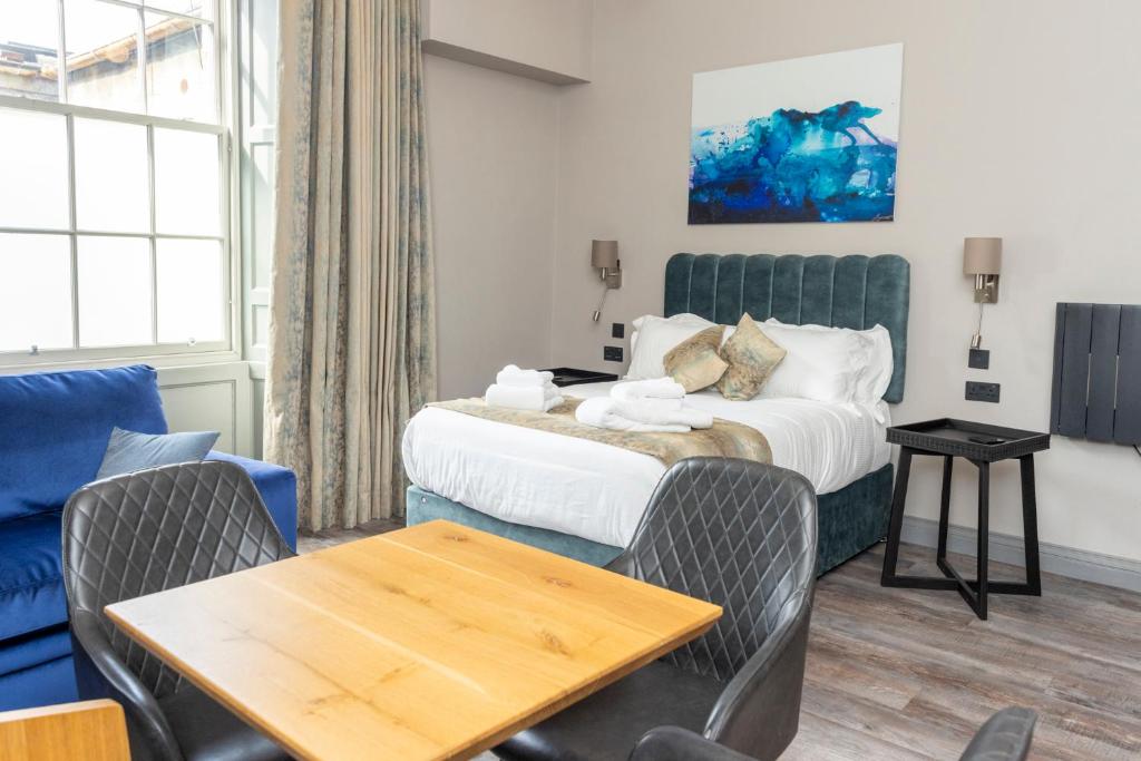 爱丁堡MONO Suites NEW TOWN的酒店客房带一张床、一张桌子和椅子