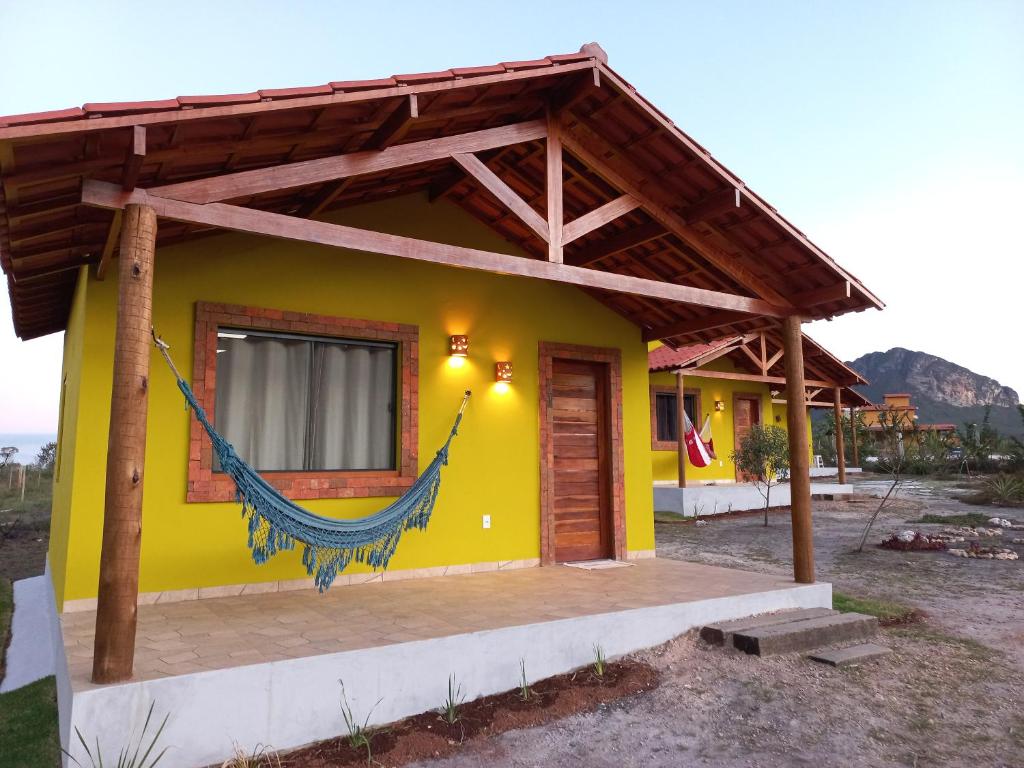 伊比科阿拉Recanto Cachoeiras de Ibicoara的一座黄色的小房子,设有木屋顶