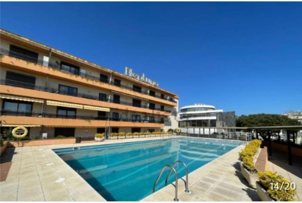 普拉加德阿罗Apartamento céntrico Playa de Aro con piscina.的大楼前的大型游泳池