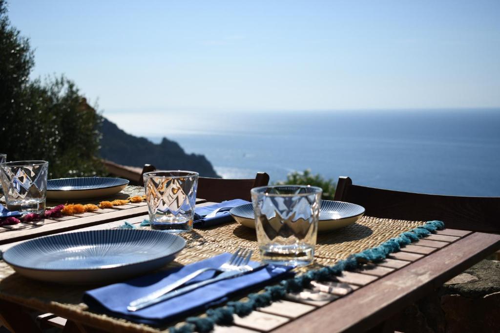 圣托斯特凡诺港BB24 - Cottage il Puntino的桌子上摆着盘子和玻璃杯,桌子上摆着大海