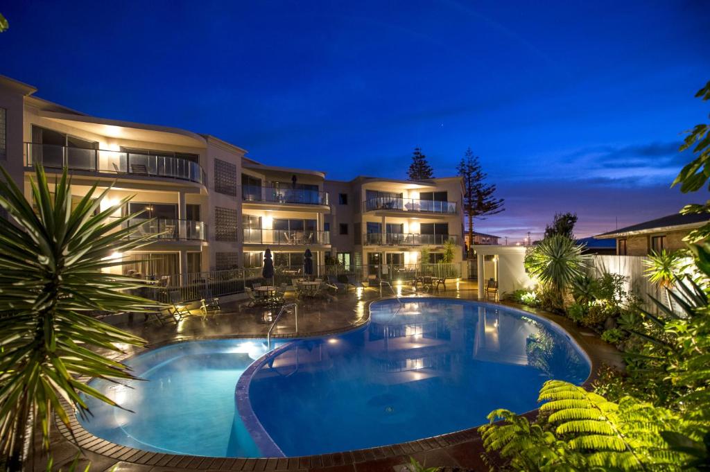 芒格努伊山礁石海滨公寓的一座大型建筑,在晚上设有大型游泳池