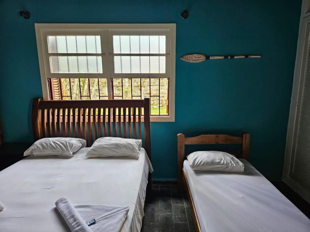 乌巴图巴Pousada da Mary的带窗户的客房内设有两张单人床。