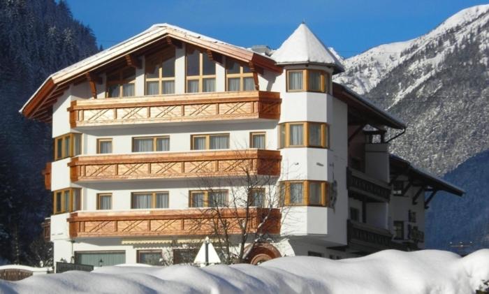 弗利尔施特洛夏娜酒店的一座大建筑,位于雪覆盖的山前