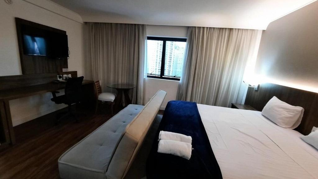 圣保罗Flat Hotel Internacional Ibirapuera 2534的酒店客房配有床、沙发和钢琴