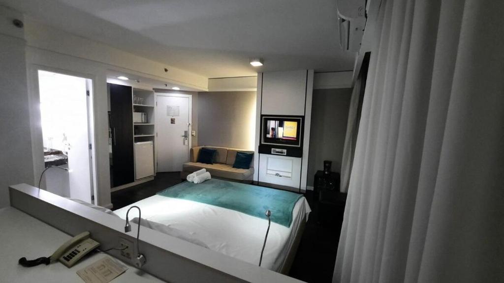圣保罗Flat Hotel av Macuco São Paulo Ibirapuera UH-2710的一间卧室配有一张大床和镜子