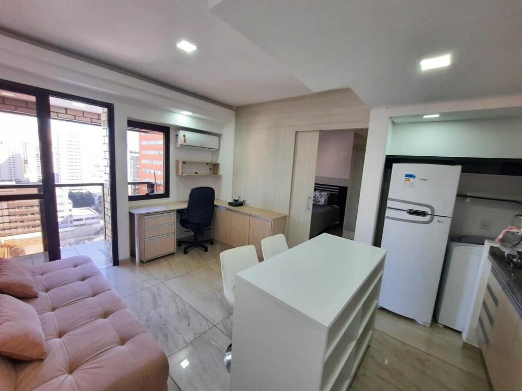 圣保罗Flat Apart-hotel QI Ibirapuera Perto do Shoping的厨房配有沙发、桌子和冰箱。