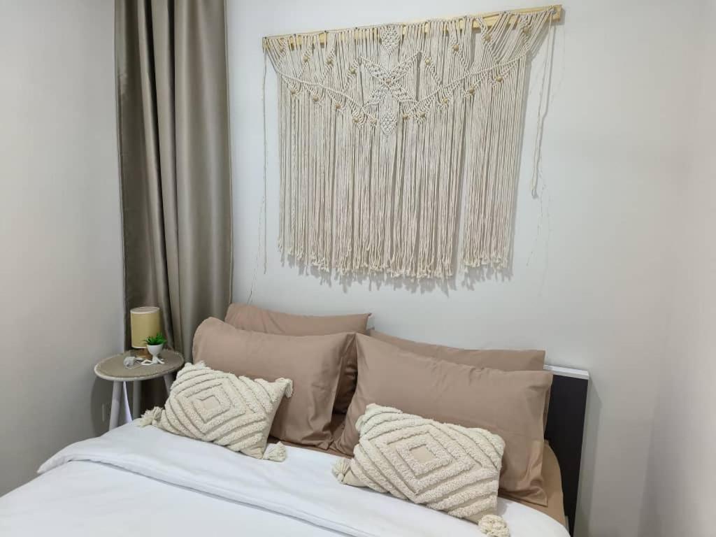 哥打京那巴鲁The Seashore House, The Shore Kota Kinabalu的卧室配有带枕头的床铺和窗户。