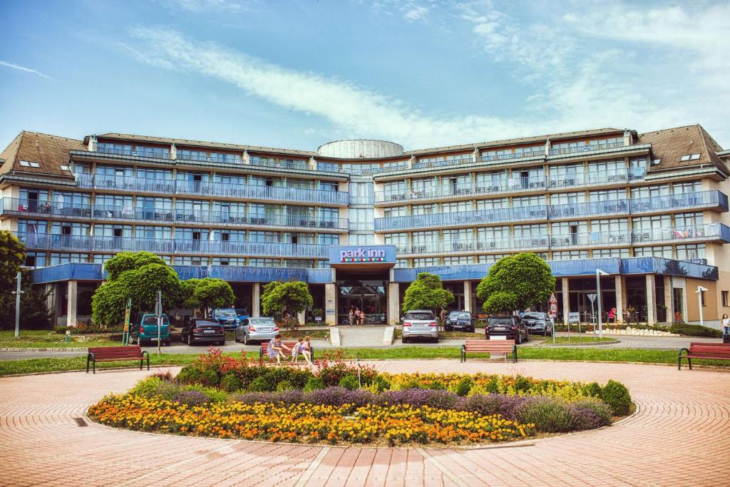 萨尔瓦尔Park Inn by Radisson Sarvar Resort & Spa - All Inclusive的一座大型建筑,前面有一个公园