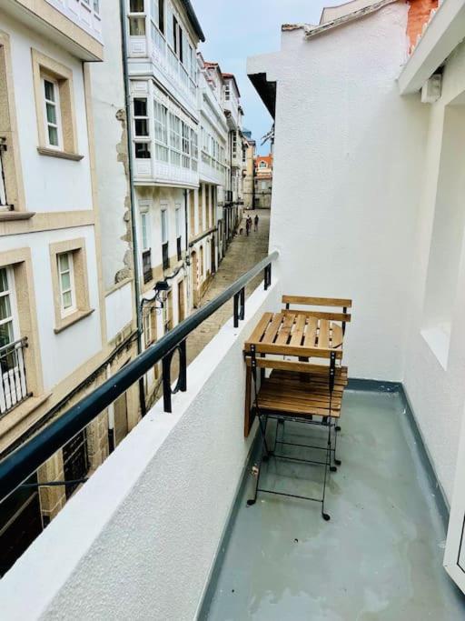 拉科鲁尼亚El sauce de la calle Sinagoga Precioso apartamento en el centro de La Coruña的坐在大楼阳台的长凳