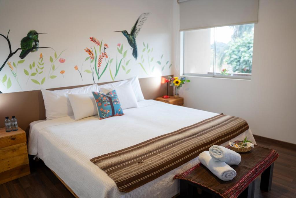 帕查卡马克Casa Boutique QX- Pachacamac的卧室配有一张白色大床,桌子上配有毛巾
