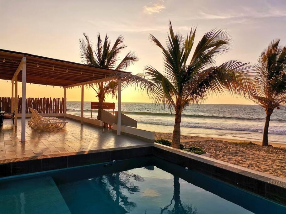卡诺阿斯德蓬萨尔Casa de Playa Las Fragatas de Punta Mero的棕榈树海滩旁的游泳池